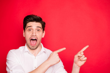 Canvas Print - Close-up portrait of his he nice lovely cheerful cheery positive glad amazed guy student employee pointing two forefingers aside ad advert novelty isolated on bright vivid shine red background