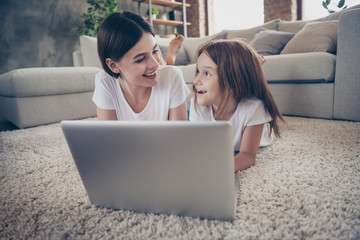 Poster - Close up photo of cute student little kid lying on floor watch netbook laughing wearing white t-shirt indoors