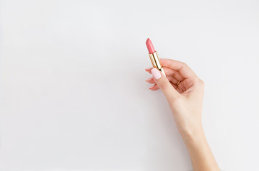 Wall Mural - Lipstick in woman's hands on white background. Make up. Open space. 