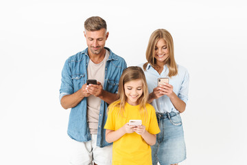 Wall Mural - Photo of attractive woman and man with little girl smiling while holding cellphones together