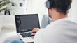 © astrosystem - Man listening to music and using laptop in the living room.