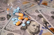 Pills and capsules in a bottle on US dollars bills. Concept of health care, pharmaceutical business, drug prices, pharmacy, medicine and economics