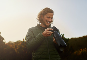 Wildlife photographer smiling after checking photos on camera