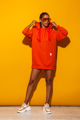 Canvas Print - Image of confident african american woman wearing sunglasses and hoodie posing at camera