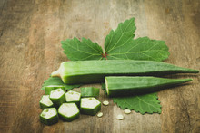 Fresh  Organic Green Okra And Leaves On Wooden Dark Tone.