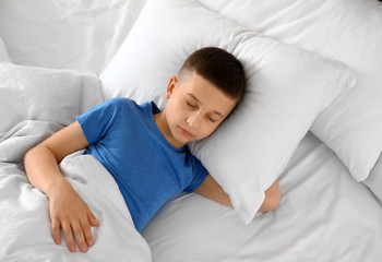 Wall Mural - Portrait of cute boy sleeping in large bed, above view