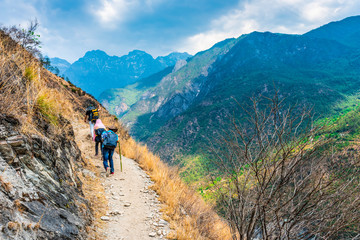 hiking trail in tiger leaping gorge. travelers hiking in the mountains. located 60 kilometres north 