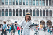 © phpetrunina14 - woman in white clothes with straw hat having fun with pigeons at venice city square