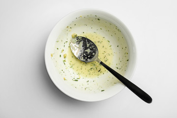 Poster - Dirty bowl with food leftovers and spoon on white background, top view