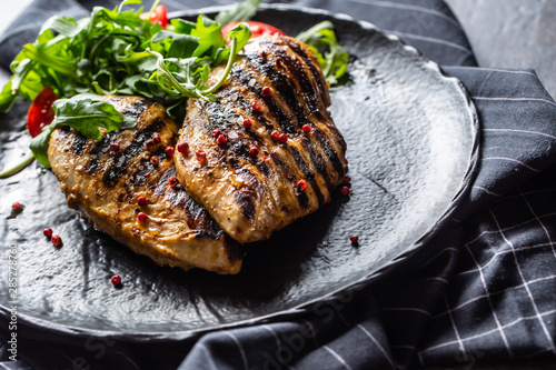 Fotografía Chicken breast grilled with spices peper salt tomatoes and arugula