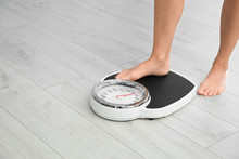 Woman Stepping On Floor Scales Indoors, Space For Text. Overweight Problem