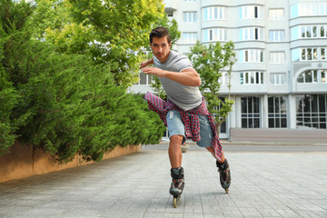 Canvas Print - Handsome young man roller skating outdoors. Recreational activity