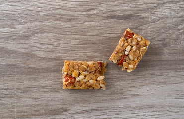 Single flax and almond seed granola bar on a table broken in half