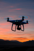 Quadrocopter With Glowing Blades Flies And Shoot The Sunset And Nature