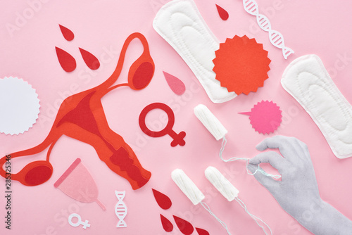 Cuadros en Lienzo cropped view of white hand holding tampon on pink background with sanitary napki