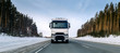 © Duet Postscriptum/Stocksy - The truck rides on a winter snowy road in the forest.