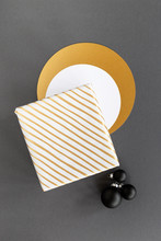 Diagonally Striped Gold And White Christmas Present And Black Ornaments