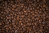 Fototapeta Kuchnia - dark background with fragrant brown coffee seeds
