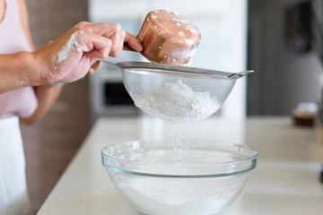 woman sifting powdered sugar