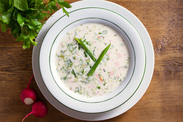 Wall Mural - Classic cold soup Okroshka made of vegetables (cucumbers, radishes and spring onions), boiled potatoes, eggs, and meat (beef, sausages or ham)