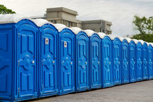 Long Row Of Portable Bio Toilet Cabins In A City Street. Line Of Chemical Toilets For The Holiday, Festival And Crowd Of People. Blue Cabines Of Bio Toilets In The City Center. WC.