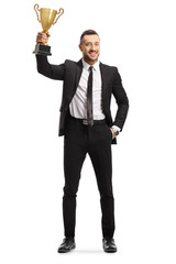 Wall Mural - Happy young man in a suit holding a golden trophy cup