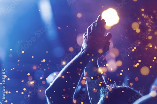Fotomural Audience with hands raised at a music festival and lights streaming down from above the stage