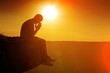 © BillionPhotos.com - Young man pray outdoor on top of mountains in sunset