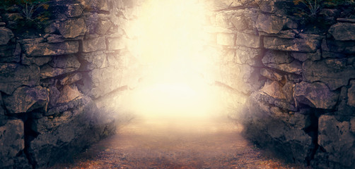 Mysterious fantasy photo background, magical trail leading out through stone dungeon cave walls towards mystical glow. Idyllic tranquil fantastic scene, empty road, way to fairytale, copy space.