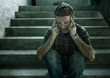 © TheVisualsYouNeed - dramatic portrait of young depressed and paranoid man sitting outdoors on dark grunge street corner staircase feeling sick suffering depression problem and anxiety crisis