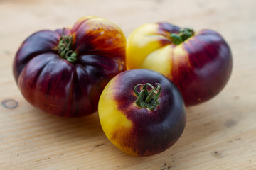 ripe varietal tomatoes on wooden background