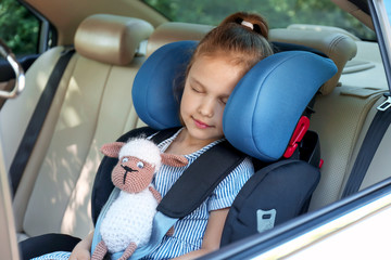 Canvas Print - Sleeping little girl buckled in car safety seat