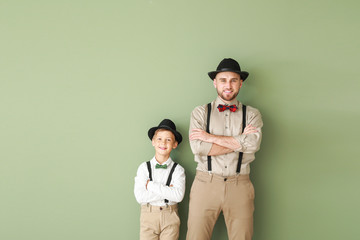 Poster - Portrait of fashionable father and son on color background