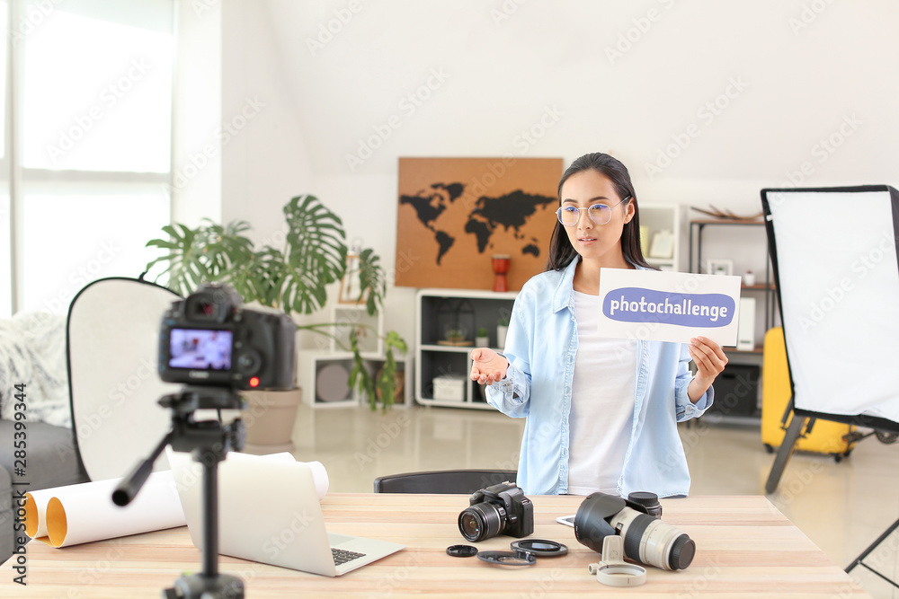 Female Asian blogger recording video at home