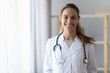 Smiling young female doctor wear medical uniform with stethoscope, portrait