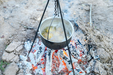 potatoes are cooked in a pot over the fire