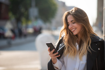 Pretty girl looking at mobile screen and smiling