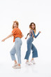 © Drobot Dean - Full length photo of two positive girls wearing colorful clothes laughing and having fun together at camera