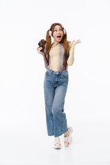 Sticker - Full length photo of positive young girl wearing headphones rejoicing while carrying retro camera