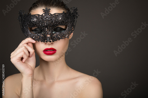 Fotografering  Fashion woman with long hair and red lipstick with a black mask