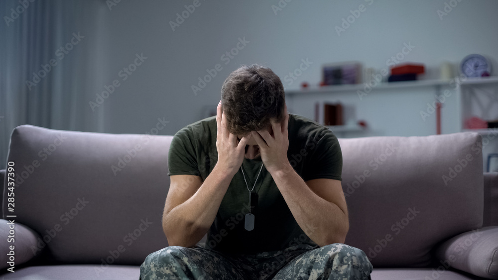 Nervous male military suffering depression, sitting alone at home, PTSD concept - obrazy, fototapety, plakaty 