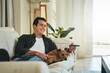 © StratfordProductions - Relaxed man lying with his dog on sofa watching tv in living roo