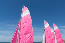 Colorful View Of Sail Tops Of Sailing Boats In Beautiful Blue Sky Day On The Beach