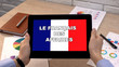 Business French application against flag on tablet in female hands, tutorial