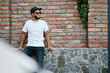 © 4Max - Hipster handsome male model with beard wearing white blank t-shirt and a baseball cap with space for your logo or design in casual urban style