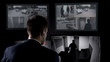 © motortion - Security guard in earphones watching robbery attempt on surveillance cameras