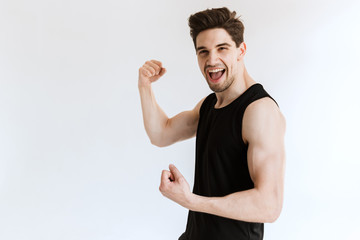 Poster - Young strong sports man posing isolated over white wall background showing biceps.