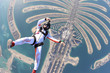 Dubai.People lies on Dubai Palm in free fall. Outdoor skydiving. Free fall on speed 200km/h. Summer sky.