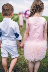 Mom with two kids walking around the field