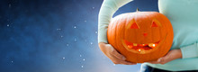 Holidays, Halloween, Decoration And People Concept - Close Up Of Woman With Pumpkin Or Jack O Lantern Over Starry Night Sky Background